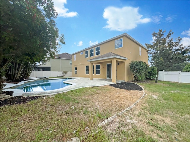 back of property with a fenced in pool, a yard, stucco siding, a patio area, and a fenced backyard