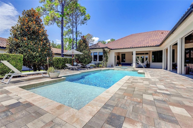 view of pool with a patio area and a pool with connected hot tub