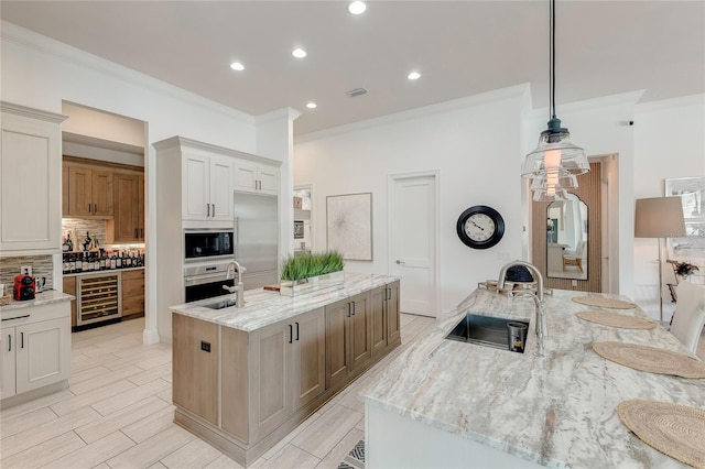 kitchen with wine cooler, oven, a kitchen island with sink, black microwave, and a sink