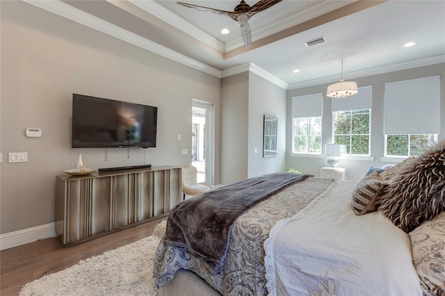 bedroom featuring ornamental molding, multiple windows, visible vents, and wood finished floors