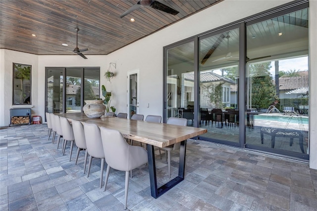 view of patio with outdoor dry bar, ceiling fan, outdoor dining area, and an outdoor pool