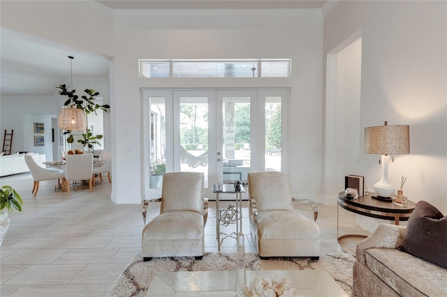 living area featuring baseboards and crown molding