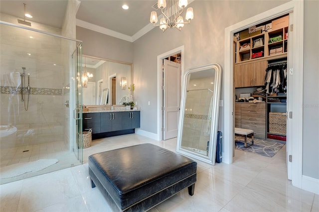 bathroom featuring an inviting chandelier, a shower stall, crown molding, and vanity