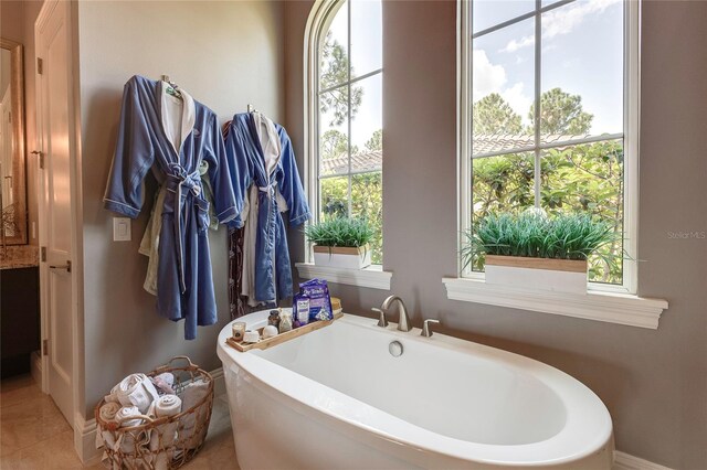 full bath with tile patterned flooring and a freestanding tub