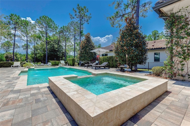 view of swimming pool with a pool with connected hot tub and a patio area