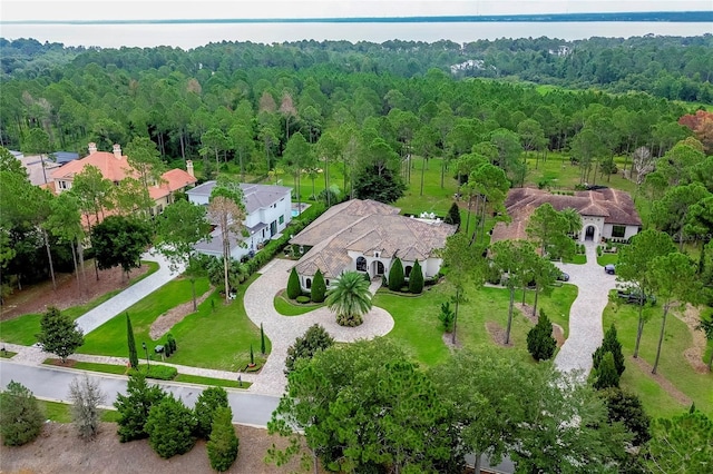 drone / aerial view featuring a water view, a forest view, and a residential view