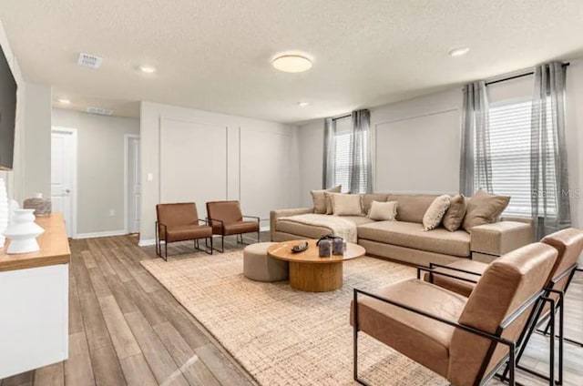 4424 Kaipo Rd, Davenport, FL 33897 - living room featuring a textured ceiling, visible vents, baseboards, light wood-type flooring, and recessed lighting