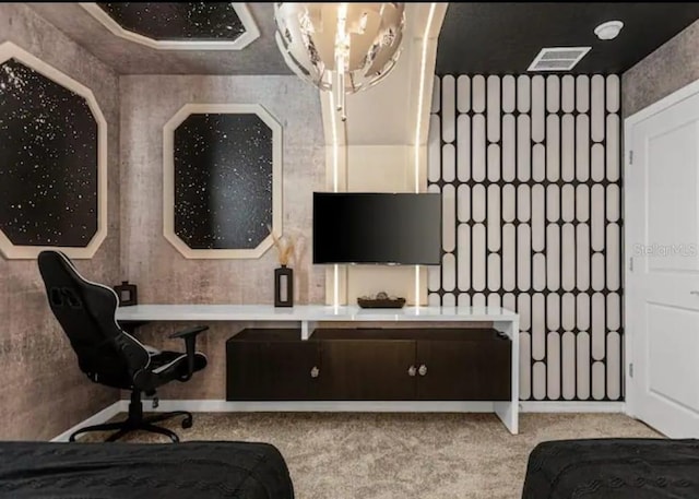 carpeted home office featuring a chandelier