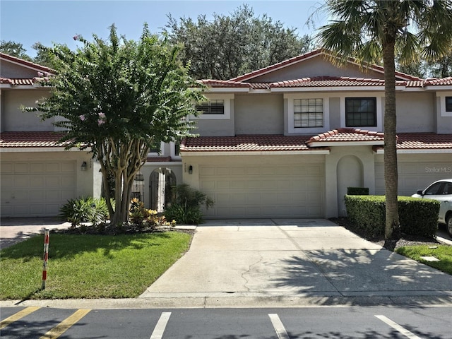 mediterranean / spanish house featuring a front yard and a garage