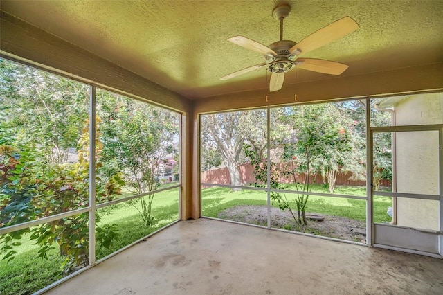 unfurnished sunroom with ceiling fan