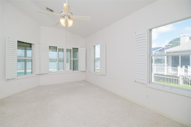 spare room featuring carpet floors, lofted ceiling, visible vents, a ceiling fan, and baseboards