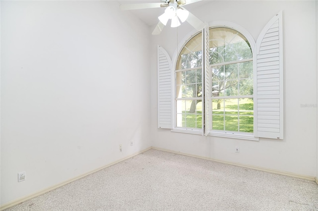 carpeted empty room with ceiling fan and baseboards