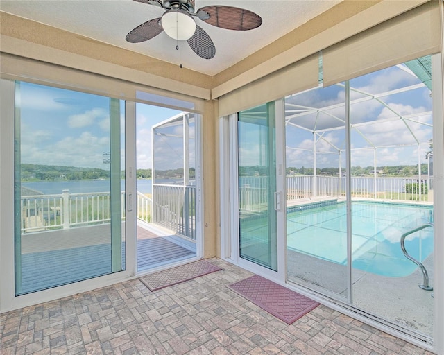 interior space with a water view and a ceiling fan