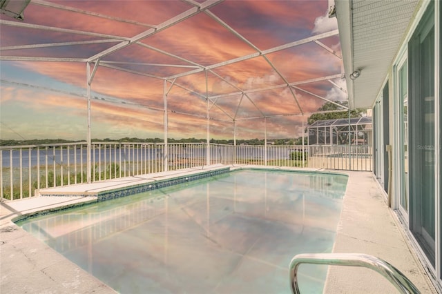 pool at dusk featuring a lanai, a fenced in pool, and fence