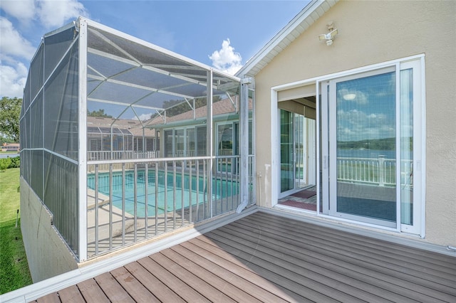 wooden terrace featuring a lanai, an outdoor pool, and a patio