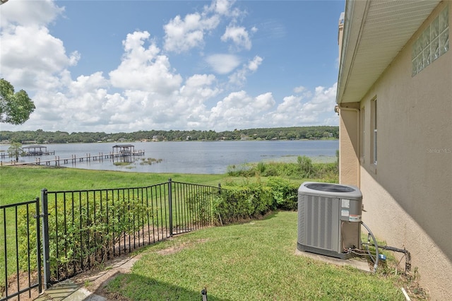 exterior space with a water view, fence, and cooling unit