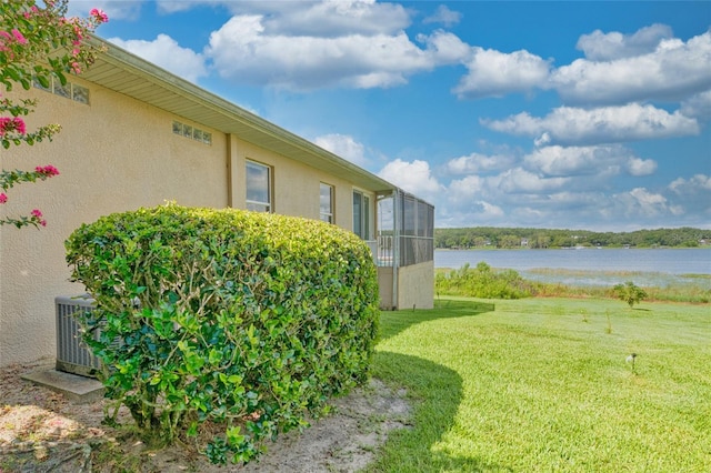 view of yard with a water view and central AC