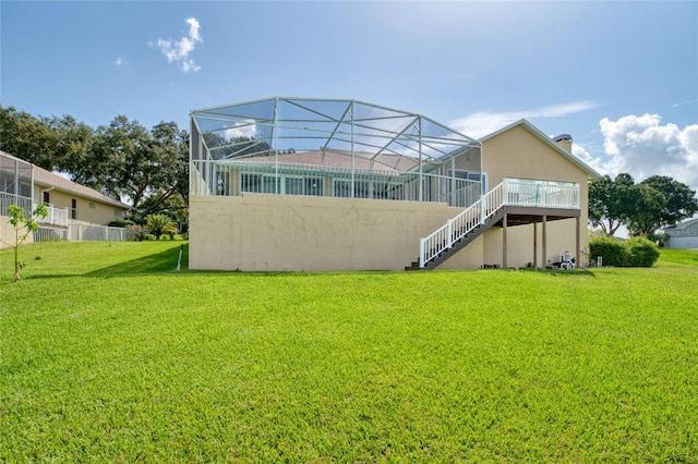 rear view of property featuring a lanai, stairs, and a yard