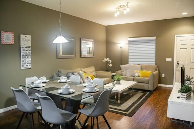 dining area featuring dark hardwood / wood-style flooring and track lighting