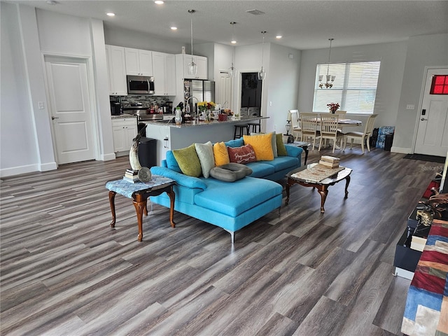 living room with dark hardwood / wood-style flooring and an inviting chandelier