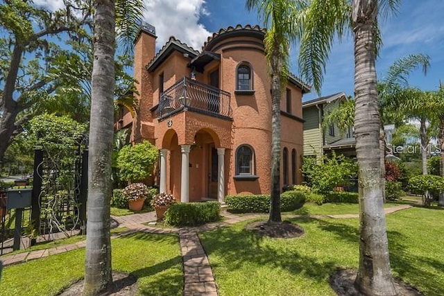 mediterranean / spanish-style home featuring a balcony and a front yard