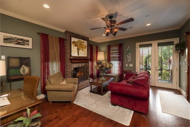 living room featuring a brick fireplace, wood-type flooring, french doors, ceiling fan, and crown molding