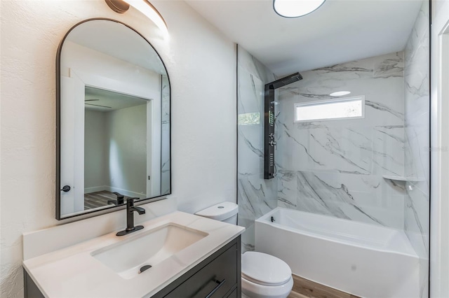 full bathroom featuring toilet, tiled shower / bath, and vanity