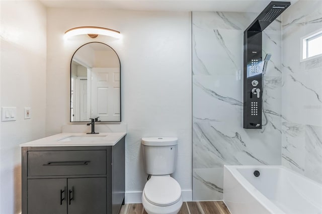 full bathroom with wood-type flooring, toilet, tiled shower / bath, and vanity