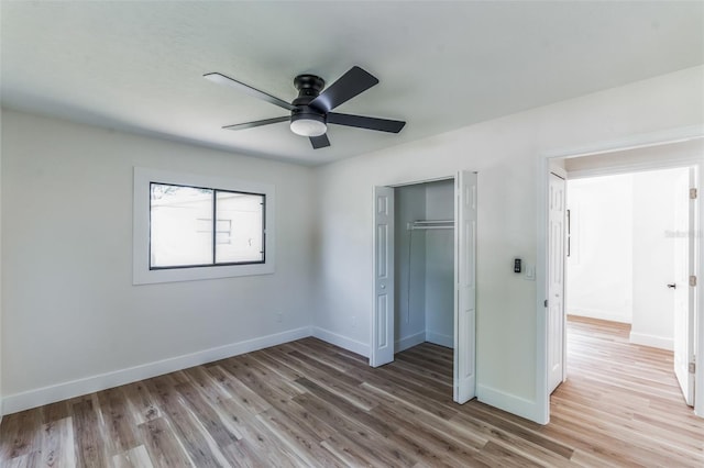 unfurnished bedroom featuring ceiling fan, wood-type flooring, and a closet