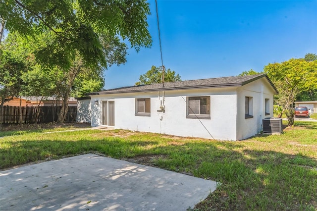 back of house with a lawn, a patio area, and central air condition unit