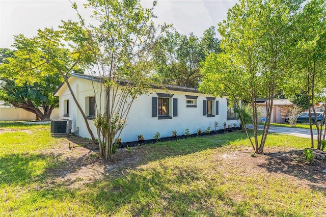 exterior space with central AC and a front yard