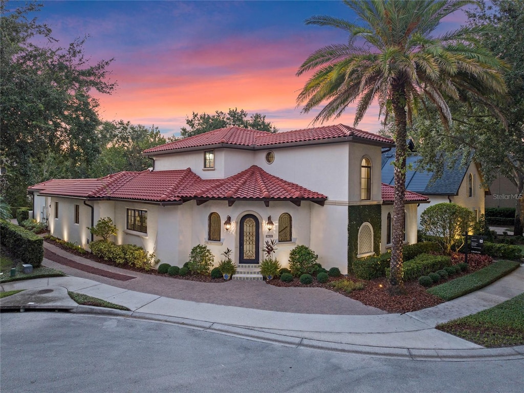 mediterranean / spanish-style home featuring a tile roof and stucco siding