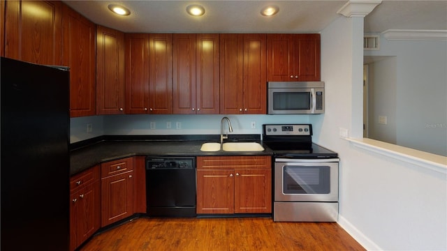 kitchen with sink, light hardwood / wood-style floors, crown molding, and black appliances