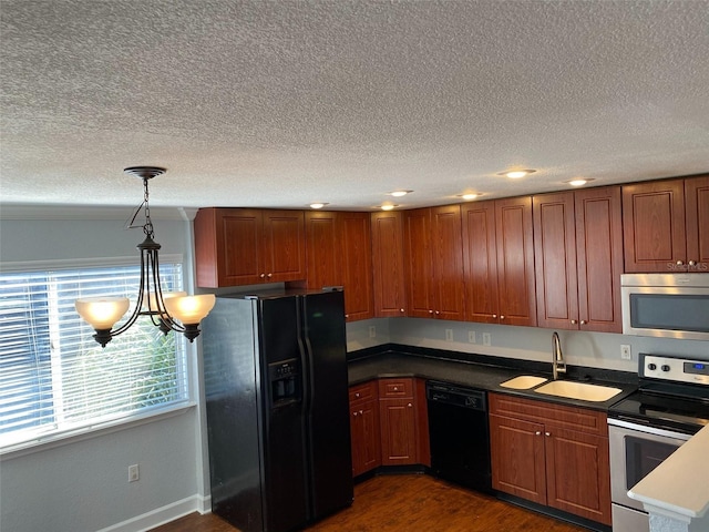 kitchen with black appliances, dark wood-type flooring, pendant lighting, sink, and an inviting chandelier