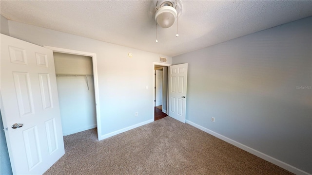 unfurnished bedroom featuring carpet, a closet, visible vents, a textured ceiling, and baseboards