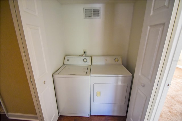 laundry area featuring washing machine and dryer and dark carpet