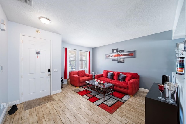 living room with a textured ceiling and light hardwood / wood-style flooring