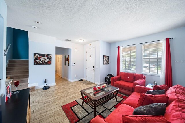 living room featuring a textured ceiling and light hardwood / wood-style floors