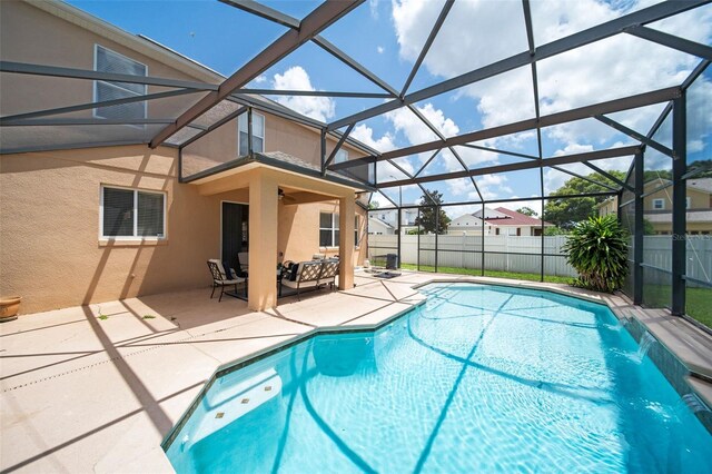 view of pool featuring a lanai, pool water feature, and a patio area