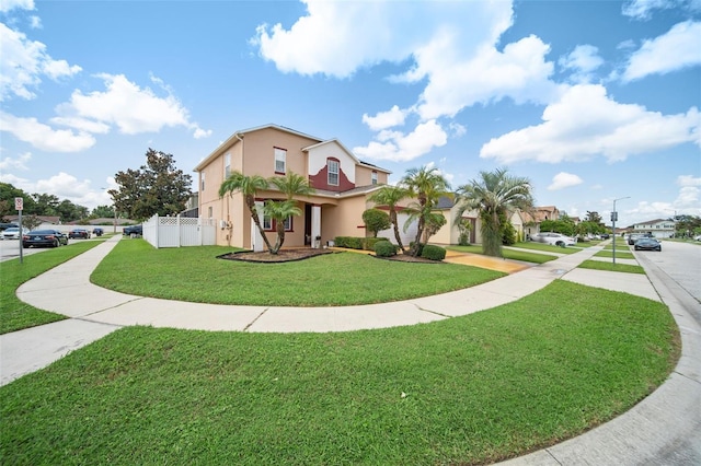 view of front of property featuring stucco siding, a front lawn, and fence