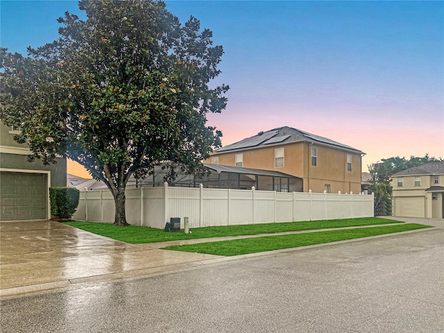 property exterior at dusk featuring a yard and a garage