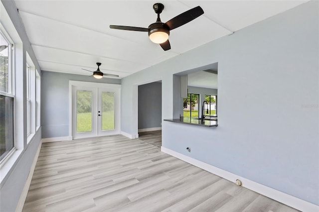 spare room featuring ceiling fan, french doors, light hardwood / wood-style floors, and sink