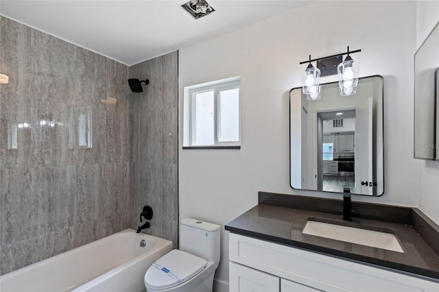 full bathroom with vanity, tiled shower / bath combo, and toilet