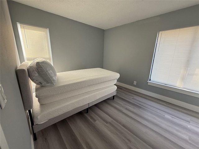 bedroom featuring a textured ceiling and hardwood / wood-style flooring