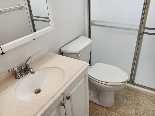 bathroom featuring vanity, a shower with shower door, and toilet