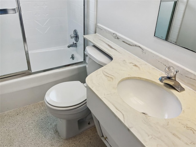 full bathroom with vanity, bath / shower combo with glass door, and toilet