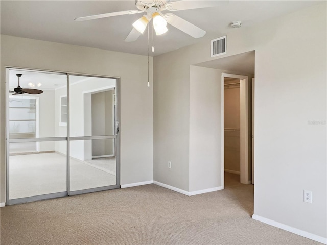 spare room featuring light carpet and ceiling fan