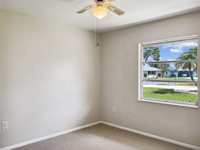 carpeted spare room featuring ceiling fan