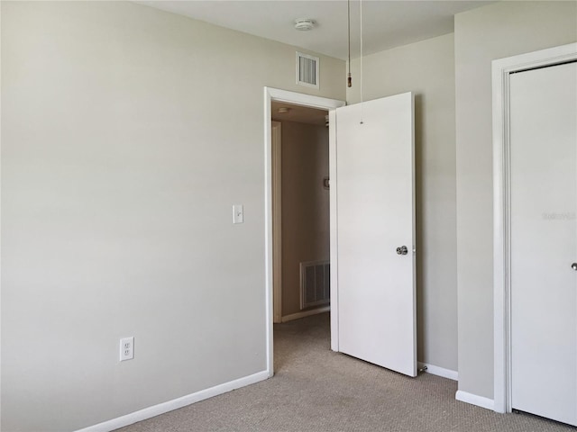 unfurnished bedroom featuring light carpet