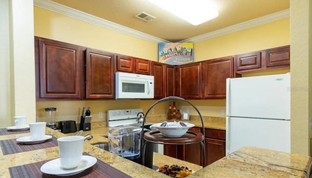 kitchen featuring crown molding, light stone countertops, and white appliances